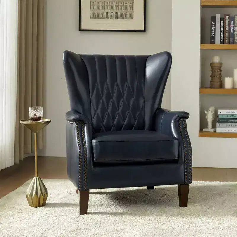 Poltrona a pozzetto in vera pelle con borchie decorative e gambe in legno massello, blu nautico